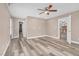 Spacious bedroom with neutral paint, wood floors, a ceiling fan, and multiple doors at 1576 Cheves Rd, Zebulon, NC 27597