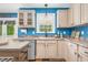 A bright kitchen featuring stainless appliances, wood cabinets, blue walls, and a window over the sink at 1576 Cheves Rd, Zebulon, NC 27597