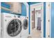 Well-lit laundry room boasts modern washer and dryer units with shelving for extra storage at 1576 Cheves Rd, Zebulon, NC 27597