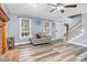Cozy living room with fireplace, wood-look floors, ceiling fan and staircase at 1576 Cheves Rd, Zebulon, NC 27597