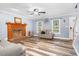 Spacious living room with a brick fireplace, wood-look flooring, and ample natural light, offering cozy comfort at 1576 Cheves Rd, Zebulon, NC 27597