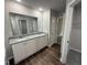 Bathroom vanity features double sinks, granite counters, white cabinets, and wood-look flooring at 163 Oakfield Trace Dr, Four Oaks, NC 27524