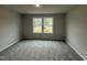 Bedroom showcasing a window view, neutral wall color, plush carpet, and electrical outlets at 163 Oakfield Trace Dr, Four Oaks, NC 27524