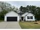 Charming one-story white home with a black garage door and landscaped front yard at 163 Oakfield Trace Dr, Four Oaks, NC 27524