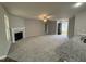 Spacious living room with a fireplace, neutral carpet, and an open entrance at 163 Oakfield Trace Dr, Four Oaks, NC 27524