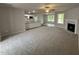 An open-concept living room flowing into the kitchen and dining area, with neutral walls and carpet at 163 Oakfield Trace Dr, Four Oaks, NC 27524