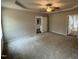 Cozy main bedroom featuring neutral walls, plush carpet, and a tray ceiling with ceiling fan at 163 Oakfield Trace Dr, Four Oaks, NC 27524