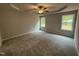 An ample primary bedroom featuring neutral walls, carpet, a ceiling fan, and large windows at 163 Oakfield Trace Dr, Four Oaks, NC 27524