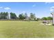 Expansive backyard with a wooden fence, lush lawn, playground, picnic table, and a patio with a grill set at 180 Packhouse Ct, Angier, NC 27501