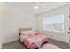 Bedroom featuring neutral walls and carpet, a bed with pink accents, and a bright window at 180 Packhouse Ct, Angier, NC 27501