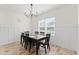 Cozy dining room with wood-look floors, modern chandelier, wainscoting, and a black dining table at 180 Packhouse Ct, Angier, NC 27501