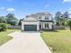Beautiful two-story home with a long driveway, attached garage, covered porch and manicured front yard at 180 Packhouse Ct, Angier, NC 27501