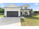 Charming two-story home featuring an attached garage and a covered porch with a rustic bench and American flag at 180 Packhouse Ct, Angier, NC 27501