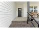 Close-up of the front porch entrance, featuring a rustic bench, black railings, and a stylish front door at 180 Packhouse Ct, Angier, NC 27501