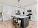 Modern kitchen featuring white cabinets, a large island with seating, stainless steel appliances, and pendant lighting at 180 Packhouse Ct, Angier, NC 27501