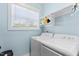 Well-lit laundry room with modern washer and dryer, a window, and storage shelves at 180 Packhouse Ct, Angier, NC 27501