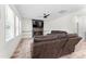 Cozy living room featuring a fireplace, large windows, ceiling fan and comfortable, reclining brown leather furniture at 180 Packhouse Ct, Angier, NC 27501