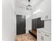 Organized mudroom with a built-in bench, coat hooks, storage cabinets, and stylish light fixture at 180 Packhouse Ct, Angier, NC 27501