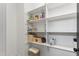 Organized pantry with white shelves and storage bins for household goods and pet supplies at 180 Packhouse Ct, Angier, NC 27501