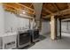 Basement laundry area showcasing washer, dryer, sink and exposed ceiling at 1809 Glendale Ave, Durham, NC 27701