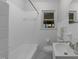 Bright bathroom with white tiles, a bathtub, and a modern sink, perfect for relaxation at 1809 Glendale Ave, Durham, NC 27701
