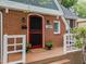 Close-up of the red brick home entrance, showcasing the red door and welcoming porch at 1809 Glendale Ave, Durham, NC 27701