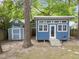 Cozy blue outbuilding features a bright white trim and a small porch, perfect for hobbies or a home office at 1809 Glendale Ave, Durham, NC 27701