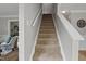 Carpeted staircase featuring white railings and neutral decor at 1832 Elkpark Dr, Raleigh, NC 27610