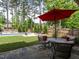 Inviting backyard with a swimming pool, outdoor seating, lush lawn, and mature trees at 200 Larkhaven Pl, Apex, NC 27539