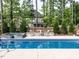 Resort-style pool area with a spa, fire pit, and cozy seating surrounded by mature trees at 200 Larkhaven Pl, Apex, NC 27539