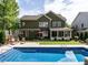 Beautiful backyard view with in-ground pool, green lawn, and charming exterior at 200 Larkhaven Pl, Apex, NC 27539