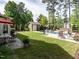 Beautiful backyard with a pool, storage shed, lush greenery, patio furniture, and a well-manicured lawn at 200 Larkhaven Pl, Apex, NC 27539
