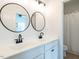 Bright bathroom featuring double sink vanity, matte black fixtures, round mirrors, and adjacent shower and toilet at 200 Larkhaven Pl, Apex, NC 27539