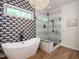 Sleek bathroom with a freestanding tub, glass-enclosed shower, and stylish wallpaper at 200 Larkhaven Pl, Apex, NC 27539