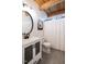 Bright bathroom with a modern vanity, round mirror, and wood-paneled ceiling at 200 Larkhaven Pl, Apex, NC 27539