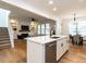 Open-concept kitchen with stainless appliances, island, and seamless flow to living & dining at 200 Larkhaven Pl, Apex, NC 27539