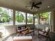 Inviting sunroom with stone floor, comfortable seating, ceiling fan, and views of the pool and backyard at 200 Larkhaven Pl, Apex, NC 27539
