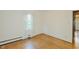 Well-lit bedroom featuring hardwood floors and a large window with flowing curtains at 2021 Bundy Ave, Durham, NC 27704