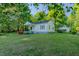 A view of the home and garage surrounded by trees and a well-maintained lawn at 2021 Bundy Ave, Durham, NC 27704