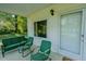 A cozy front porch has seating, a window, and an exterior door at 2021 Bundy Ave, Durham, NC 27704