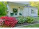 Charming front porch with chairs, complemented by vibrant azaleas and a manicured lawn at 2021 Bundy Ave, Durham, NC 27704