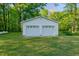 Detached two-car garage with white doors and green grass in a spacious backyard at 2021 Bundy Ave, Durham, NC 27704
