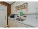This kitchen includes a double sink, white cabinets, and decorative curtains over the window at 2021 Bundy Ave, Durham, NC 27704