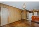 Cozy living room featuring wood-paneled walls, hardwood floors, and vintage lighting fixtures at 2021 Bundy Ave, Durham, NC 27704