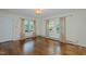 Bright living room boasts hardwood floors, neutral walls, and natural light from large windows at 2021 Bundy Ave, Durham, NC 27704