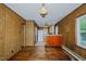 Combined living space with hardwood floors, wood-paneled walls, and kitchen access at 2021 Bundy Ave, Durham, NC 27704