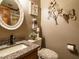 Cozy bathroom featuring granite countertop, decorative mirror, and flower wall decor at 204 Wiley Oaks Dr, Wendell, NC 27591
