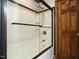 Bright white tiled shower with glass door and chrome fixtures adjacent to wooden door at 204 Wiley Oaks Dr, Wendell, NC 27591