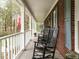 Inviting front porch with rocking chairs, brick facade, and white columns at 204 Wiley Oaks Dr, Wendell, NC 27591