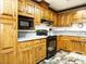 Close up of a kitchen with oak cabinets, black appliances, and a light countertop at 204 Wiley Oaks Dr, Wendell, NC 27591